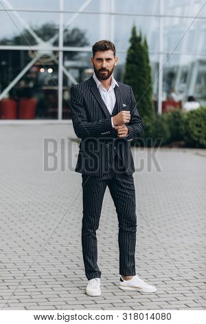 Confident Businessman. Confident Young Man In Full Suit Adjusting His Sleeve And Looking Away While 