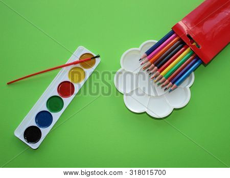 Brush, Paint, Eraser, Pencils On A Green Background. Watercolor And Colored Objects For School And C