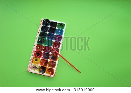 Brush, Paint On A Green Background. Watercolor And Colored Objects For School And Creativity.