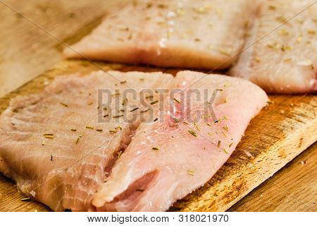 Raw Luce Fillet With Rosemary Herb On Cutting Board Close Up Detail
