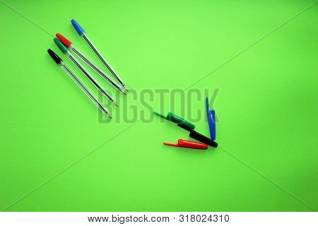 Colored Writing Pens. Colorful Items For School, Office On A Green Background.