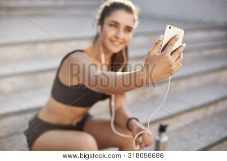 Blurred Shot With Focus On Smartphone, Attractive Cheerful Female Athlete Sit Outdoors Staircase, Li