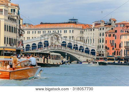 Venice, Italy - May 25, 2019: View Of Grand Canal Full Of Boats And Gandolas Rialto Bridge On Backgr