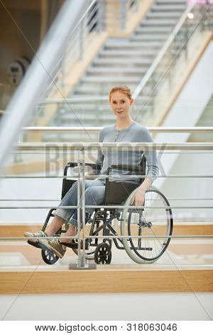 Portrait Of Young Disabled Woman In Casual Cloting Sitting In Wheelchair And Looking At Camera At Mo