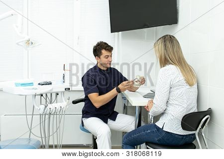 Professional Dentist Shows Model Of Jaw To His Client. Slective Focus
