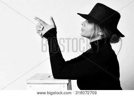 Black And White Portrait In Profile Of Blonde Woman In Black Hat With Brim And Turtleneck Sweater Do