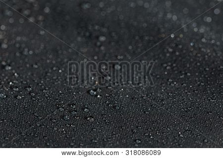 Dark Gray Waterproof Hydrophobic Flat Cloth Closeup With Rain Drops Selective Focus Background
