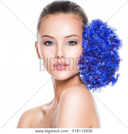Face of a beautiful girl  with blue posy fild flowers. Skin care concept.