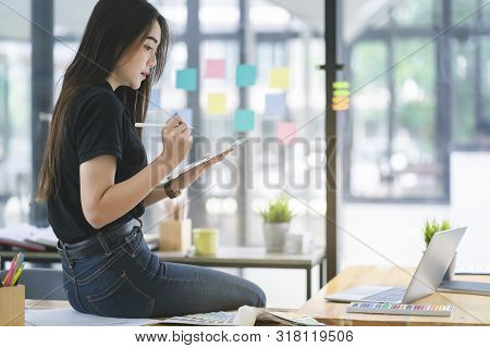 Young Asian Graphic Designer Working On Computor And Graphics Tablet In Her Working Space