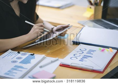 Young Asian graphic designer working on computor and graphics tablet in her working space