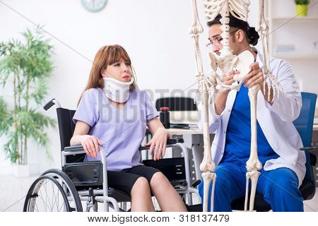 Young woman in wheel-chair visiting male doctor 