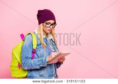 Photo Of Attractive Girl Wearing Cap Making Notes In Her Notepad Preparing To Exam While Isolated Wi