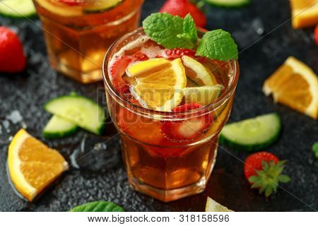 Refreshing Pimms Cocktail With Fruit And Vegetables On Rustic Black Table