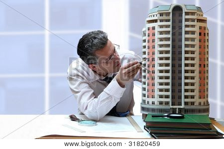 Architect met een breadbord model van een gebouw