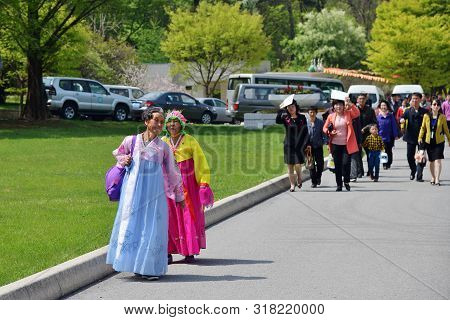 Pyongyang, North Korea - May 1, 2019: Two Old Women In Traditional Korean Hanbok Dress And Another L