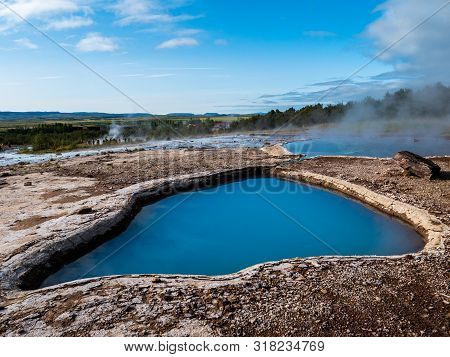Blue Geothermal Pond At The Great Geysir, An Active Volcanic Geyser In Southwestern Iceland