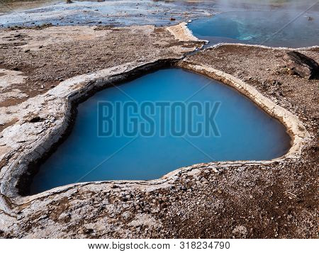 Blue Geothermal Pond At The Great Geysir, An Active Volcanic Geyser In Southwestern Iceland