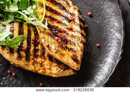 Chicken Breast Grilled With Spices Peper Salt Tomatoes And Arugula.