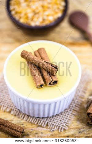 Dessert Of Curau. Brazilian Sweet Corn, Corn Mousse With Cinnamon On A Wooden Background. Typical Br