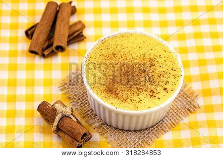 Dessert Of Curau. Brazilian Sweet Corn, Corn Mousse With Cinnamon On A Wooden Background. Typical Br