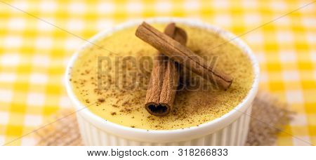 Dessert Of Curau. Brazilian Sweet Corn, Corn Mousse With Cinnamon On A Wooden Background. Typical Br