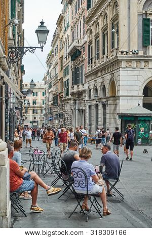 Genoa , Italy - July 7, 2019: Rerspective of San Lorenzo street in Genoa with people at cafe