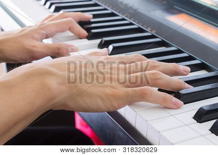 Hand Of Piano Player On White Keys And Black Keys Of Electric Piano In Crosswise View