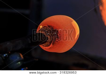 Glass Blower Manufacturing Process, Working On A Bubble Of Melted Glass On A Rod By Heating It Up By