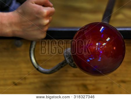 Glass Blower Shaping A Bubble Of Melted Glass On A Rod By Hand In The Manufacturing Process At A Gla