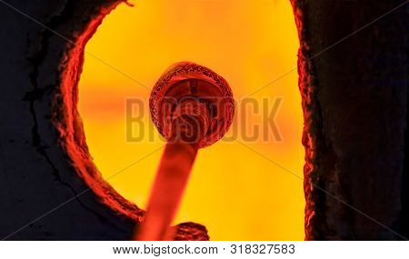 Glass Blower Manufacturing Process, Working On A Bubble Of Melted Glass On A Rod By Heating It Up By
