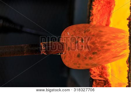 Glass Blower Manufacturing Process, Working On A Bubble Of Melted Glass On A Rod By Heating It Up By