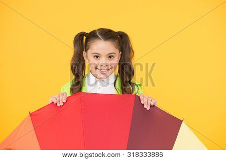 Hiding From Rain. Smiling Schoolgirl Peeking Out Of Colorful Umbrella. Autumn Rain. Going To School 