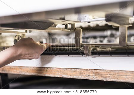 printing operator working on an offset printing maschine checking the final print