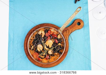 Mediterranean Black Pasta With Shrimps, Tomatoes, Dumplings, Rosemary And Mushrooms
