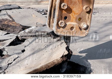 Machine Drills Asphalt. Large Fragments Of Land And Pits Everywhere On The Road. Working Equipment W