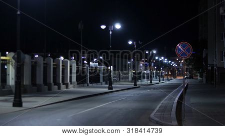 Empty Roadway Lit By Lanterns On Night. Stock Footage. Summer Night In City Illuminated By White Lig