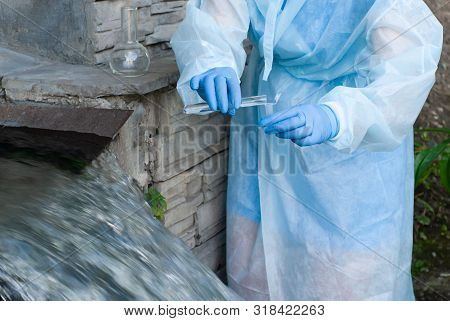 Female Sanitary Inspector Or Epidemiologist Takes A Sample Of Water From Urban Wastewater