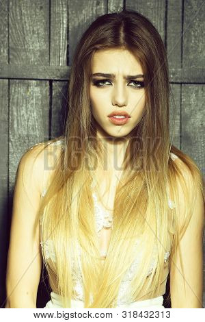 Portrait Of Sad Thoughtful Young Blone Woman With Long Beautiful Hair In Lace Dress On Wooden Backgr