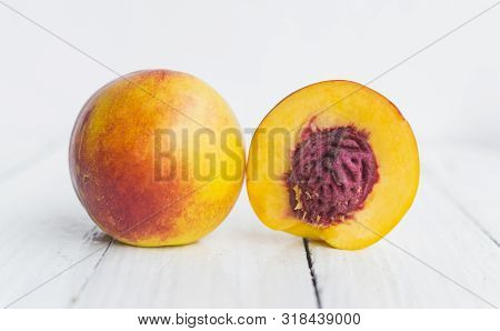 Delicious And Juicy Peach (nectarina) On White Wooden Table With Place For Text.