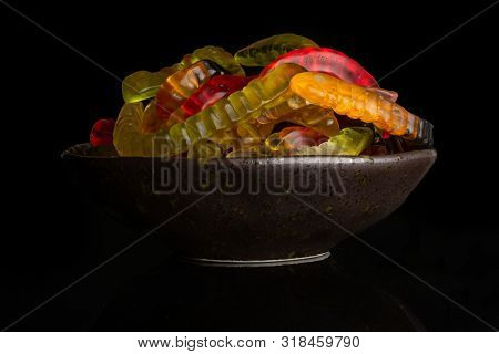 Lot Of Whole Colourful Jelly Worm Candy On Grey Ceramic Plate Isolated On Black Glass