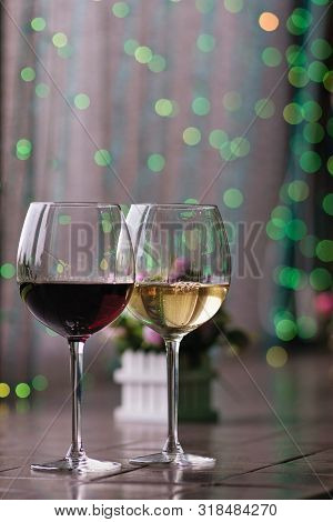 Two Glasses Of Wine White And Red Standing On A Table. Colorful Bokeh. Wine Tastings, Wine Tour. Col