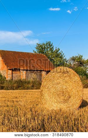Straw Ball On Field In The Czech Republic. Harvested Field. Morning On The Far. Hay Bales After Harv