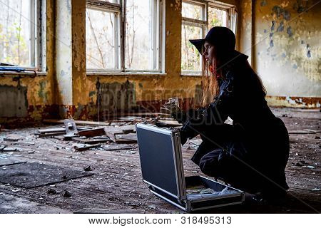 Girl In A Black Cloak With A Diplomat And Money In A Ruined Room. A Spy In A Secret Meeting. Unusual