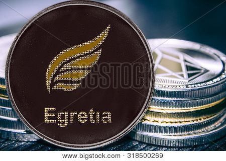Coin Cryptocurrency Egretia Egt On The Background Of A Stack Of Coins.