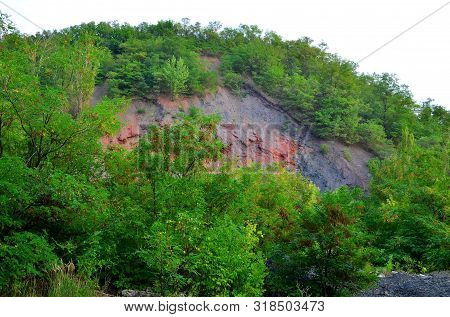 The Mine Waste Heap Is Buried In Green Vegetation.