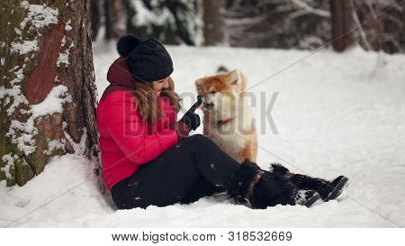 Portrait With A Cute Fluffy Puppy. Winter Walk With A Dog. Young Woman Walks With The Puppy, Snowy W