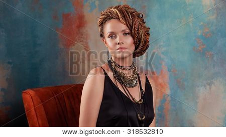 Southern Flavor. Stylish Beautiful Young Woman With Afro Braids Tucked Into A High Hair, Sitting In 