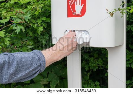 The Man With Two Hands Take Cellophane Gloves On The Gas Station.