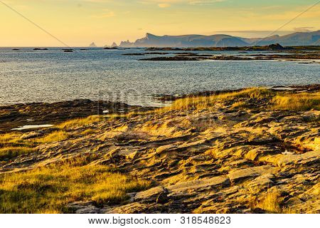 Seascape On Andoya Island. Scenic Rocky Coastline With Mountain Peaks In Distance, View From Bukkekj