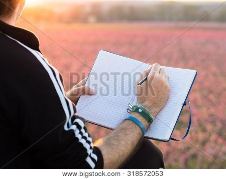Hand Of Boy Drawing In The Field